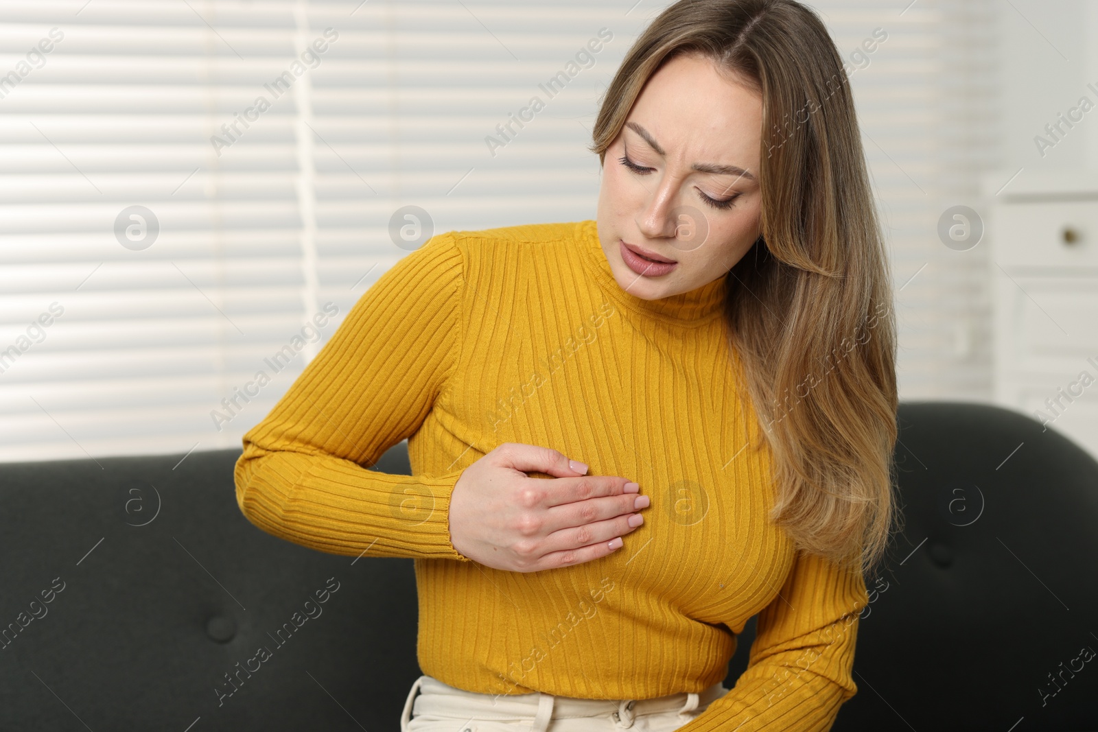 Photo of Mammology. Young woman doing breast self-examination at home