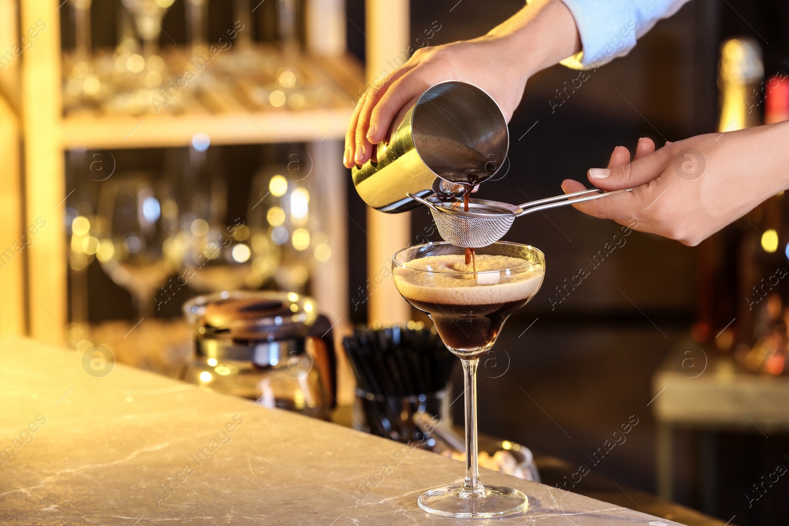 Photo of Woman preparing Espresso Martini on bar counter, closeup. Alcohol cocktail