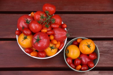 Photo of Bowls with fresh tomatoes on wooden table, flat lay