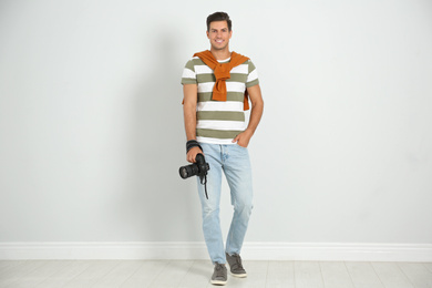 Photo of Professional photographer working near white wall in studio