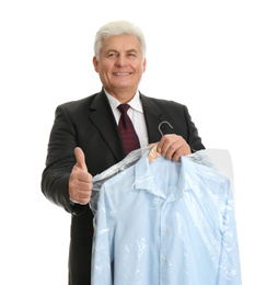 Photo of Senior man holding hanger with shirt in plastic bag on white background. Dry-cleaning service