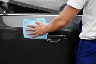 Man washing car door with rag, closeup