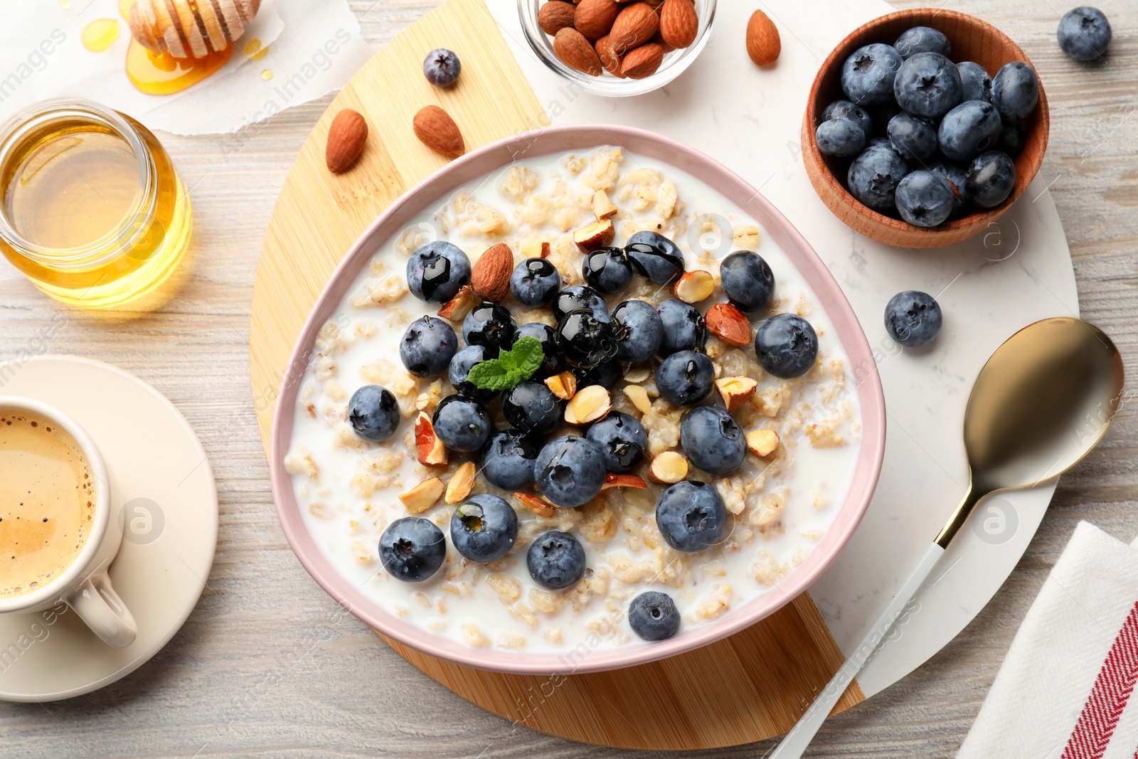 Photo of Flat lay composition with tasty oatmeal porridge and ingredients served on wooden table. Healthy meal