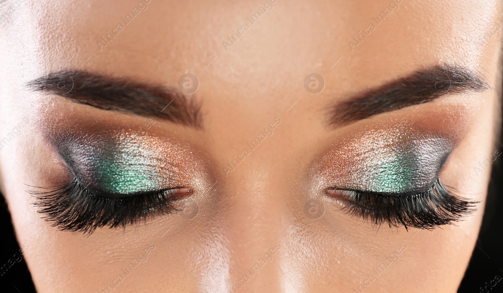 Photo of Young woman with eyelash extensions and beautiful makeup, closeup view