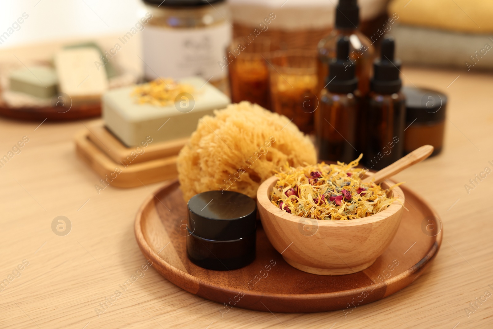 Photo of Dry flowers, loofah and jar of cream on wooden table, space for text. Spa time