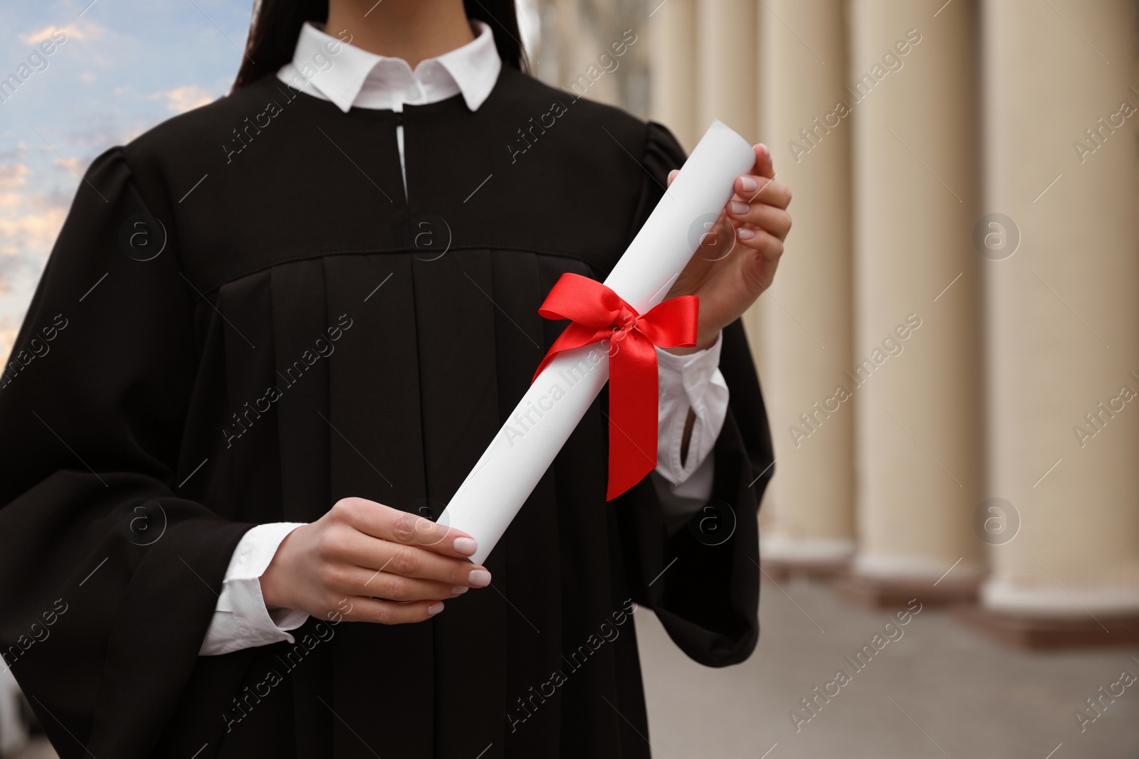 Photo of Student with diploma after graduation ceremony outdoors, closeup. Space for text