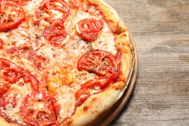 Photo of Hot cheese pizza Margherita on wooden table, closeup. Space for text