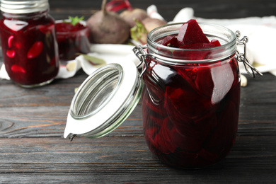 Photo of Pickled beets in glass jar on wooden table