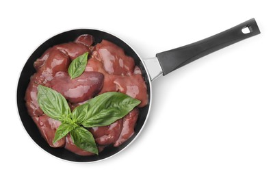 Photo of Raw chicken liver with basil in frying pan isolated on white, top view