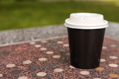 Photo of Paper cup on parapet table, space for text. Coffee to go
