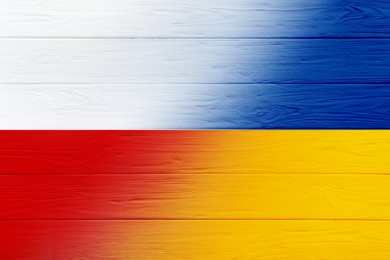 Flags of Ukraine and Poland on wooden background. International diplomatic relationships