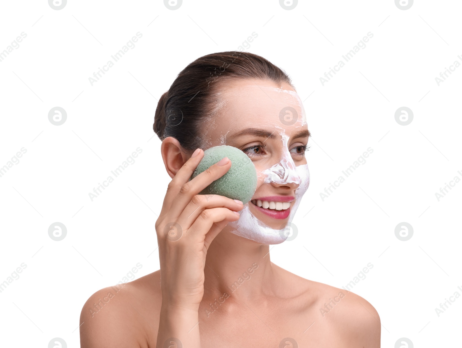 Photo of Happy young woman washing off face mask with sponge on white background