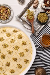 Photo of Making delicious baklava. Raw dough with ingredients on white wooden table, flat lay
