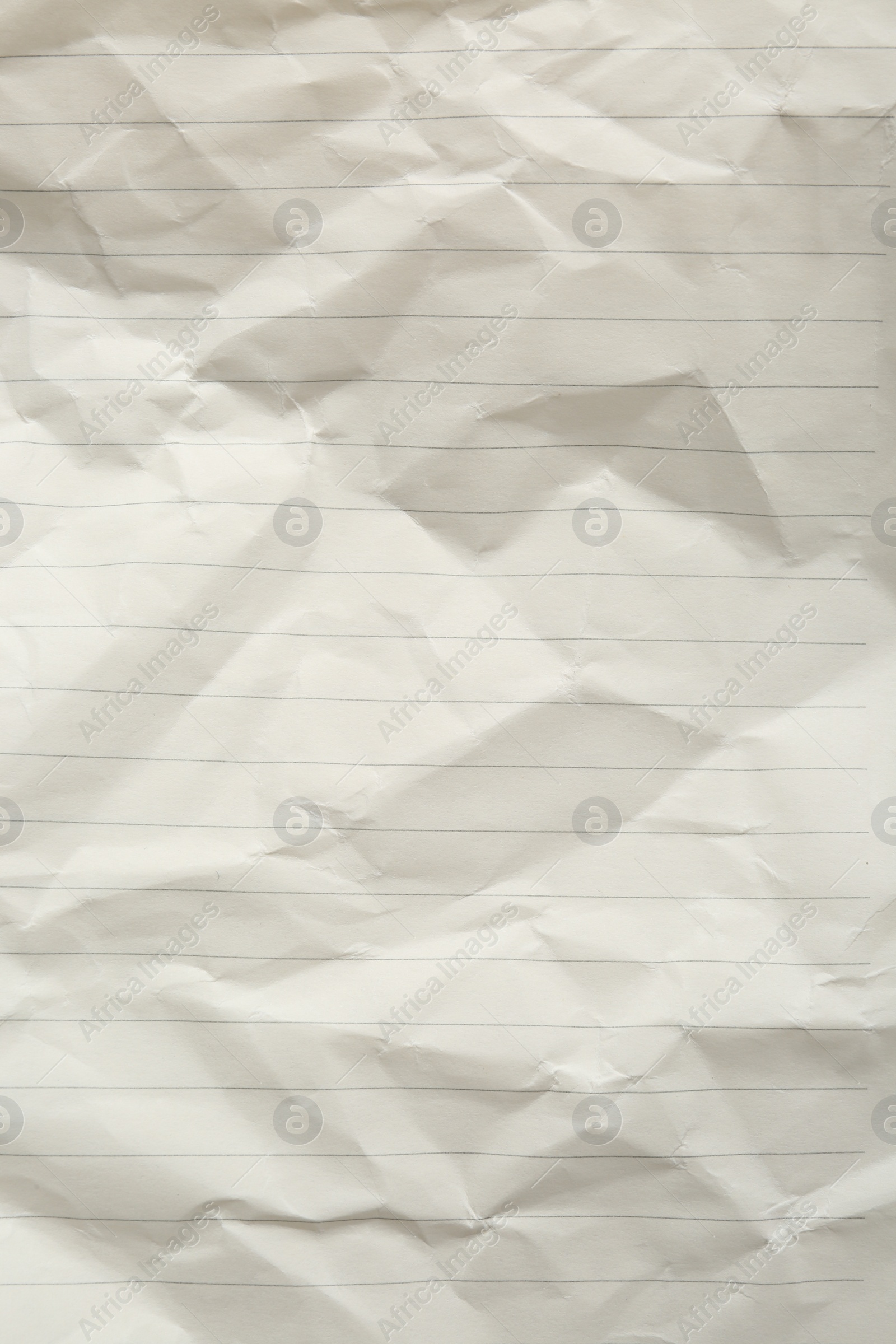 Photo of Crumpled lined notebook sheet as background, top view