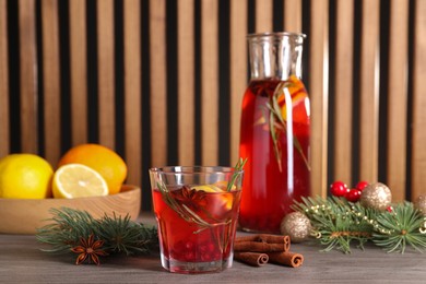 Aromatic punch drink and Christmas decor on wooden table, space for text