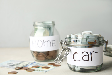 Photo of Glass jar with money and tag CAR on white table