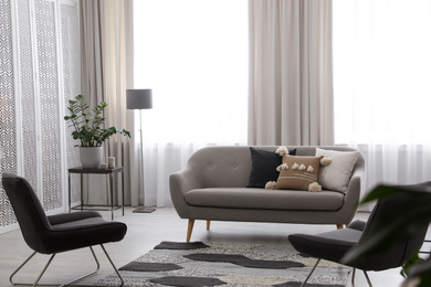 Modern living room interior with comfortable sofa and armchairs