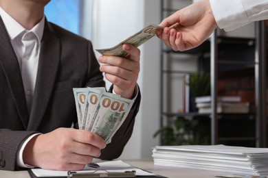 Photo of Man giving money to woman indoors, closeup. Currency exchange