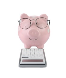 Photo of Calculator and pink piggy bank in glasses isolated on white