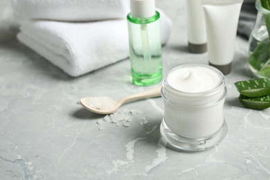 Photo of Different cosmetic products and aloe on grey marble table