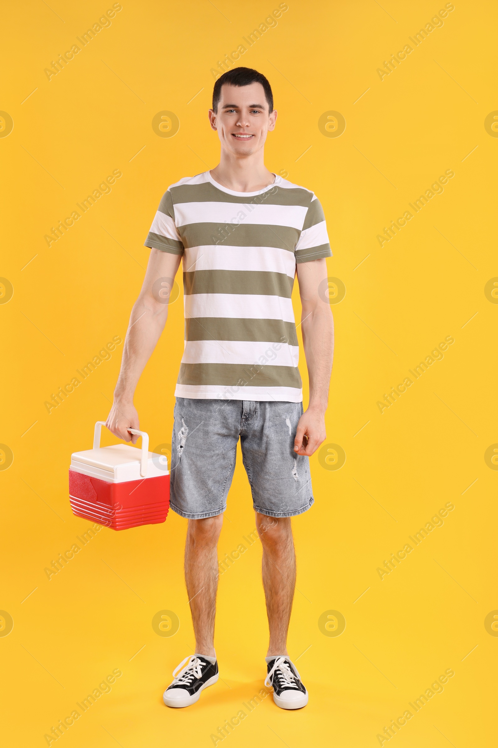 Photo of Man with red cool box on orange background