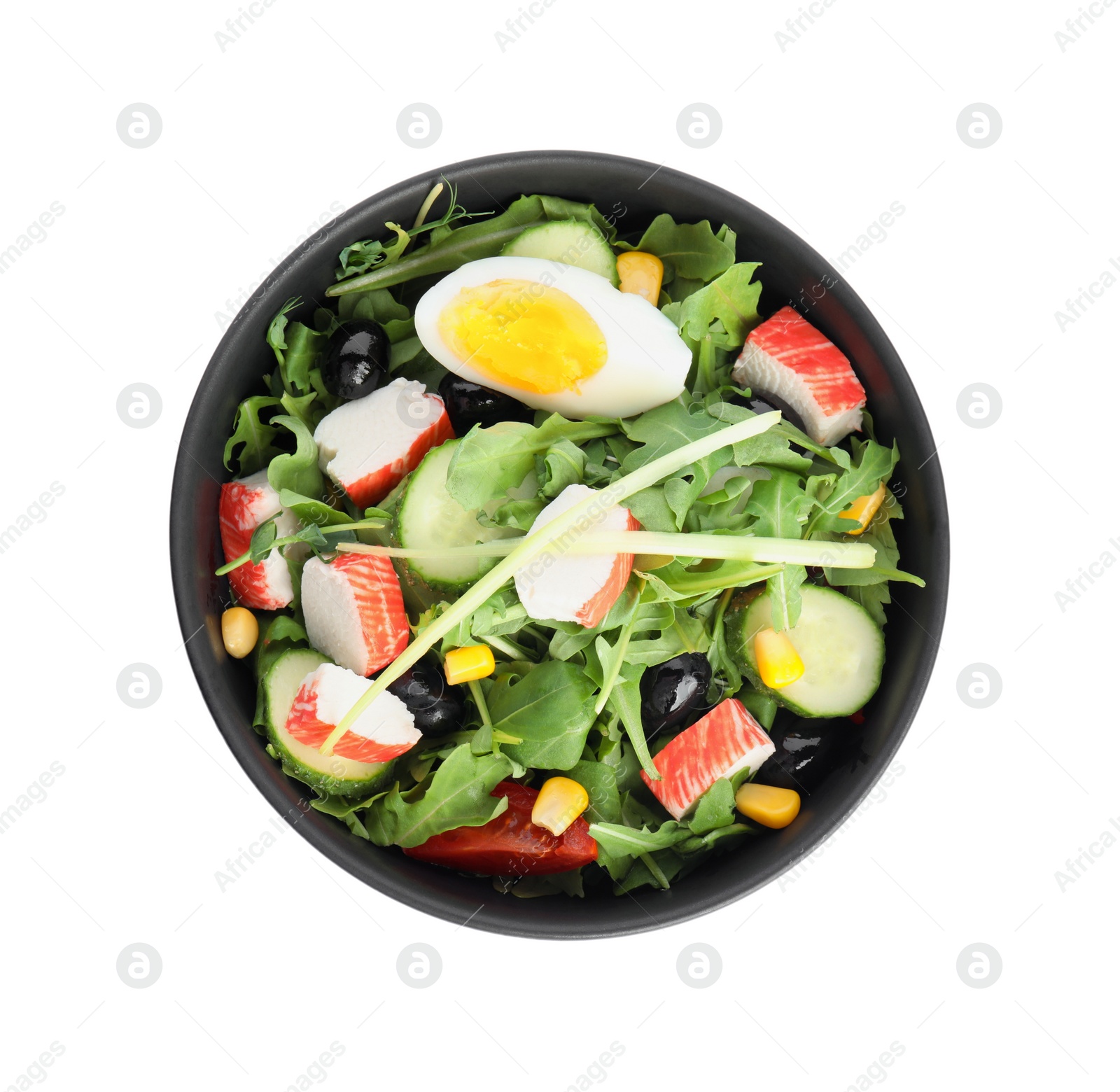 Photo of Tasty crab stick salad in bowl isolated on white, top view