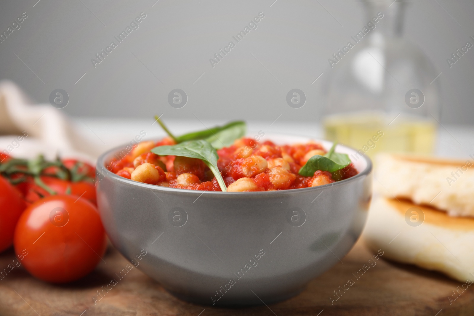 Photo of Delicious chickpea curry with basil in bowl, closeup