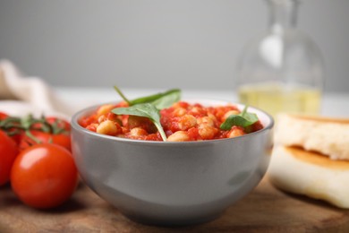 Delicious chickpea curry with basil in bowl, closeup