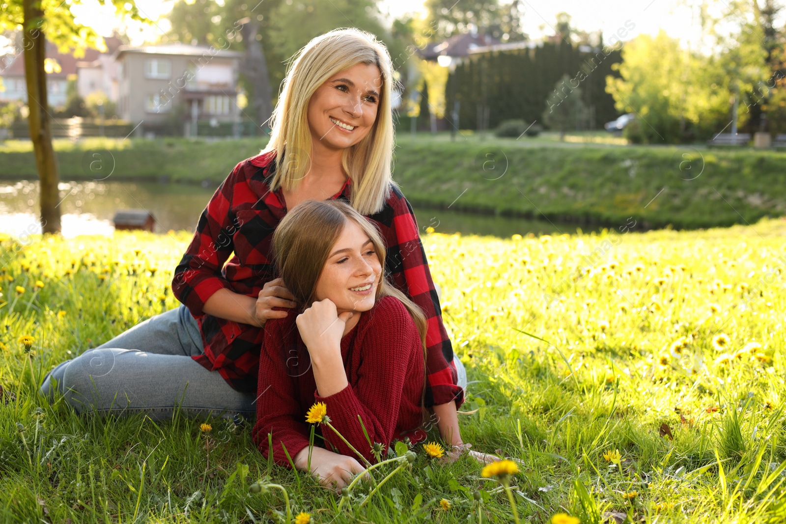 Photo of Happy mother with her daughter on green grass in park