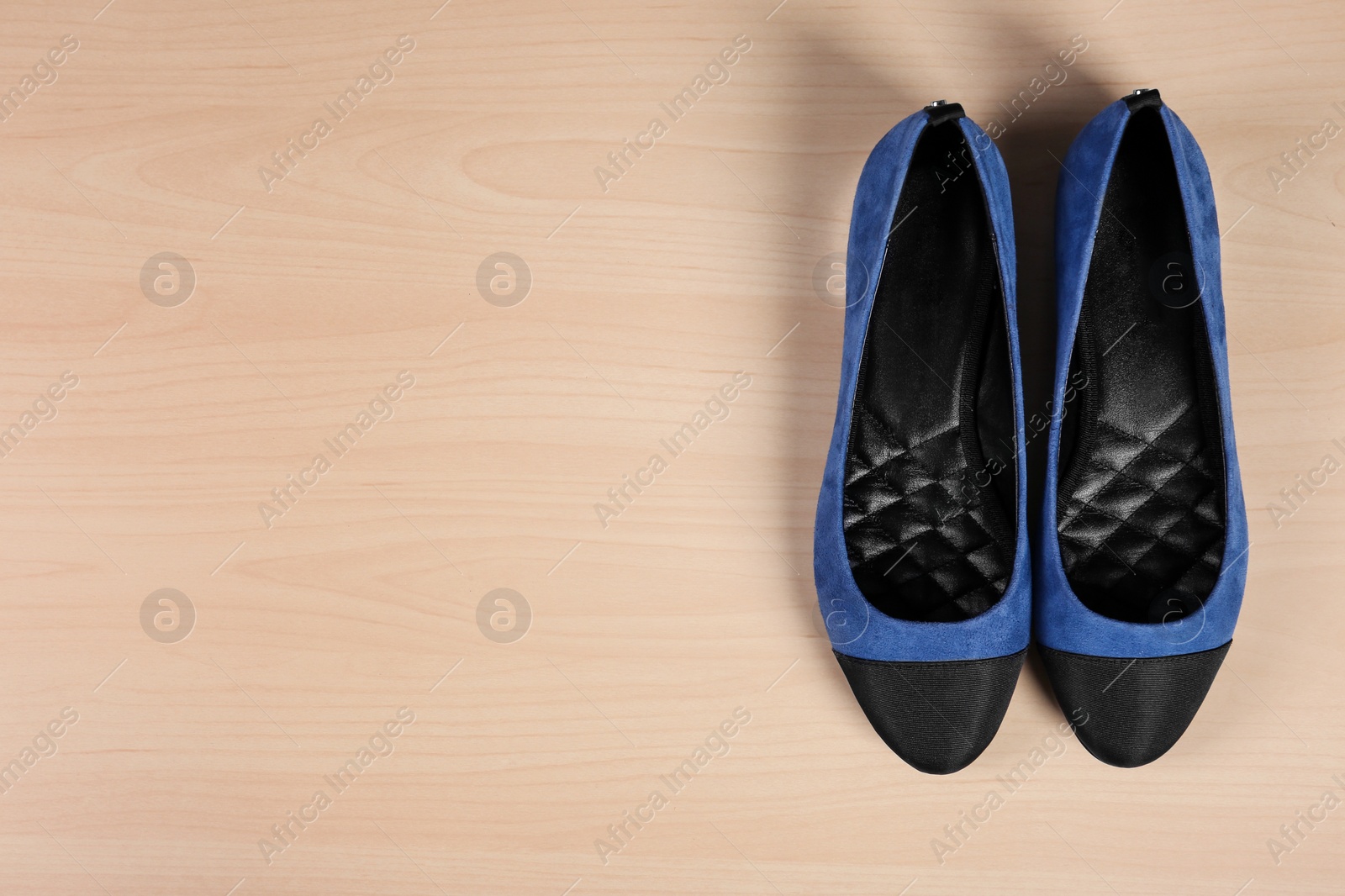 Photo of Pair of shoes on wooden background, top view