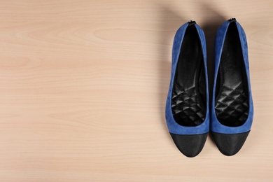 Photo of Pair of shoes on wooden background, top view