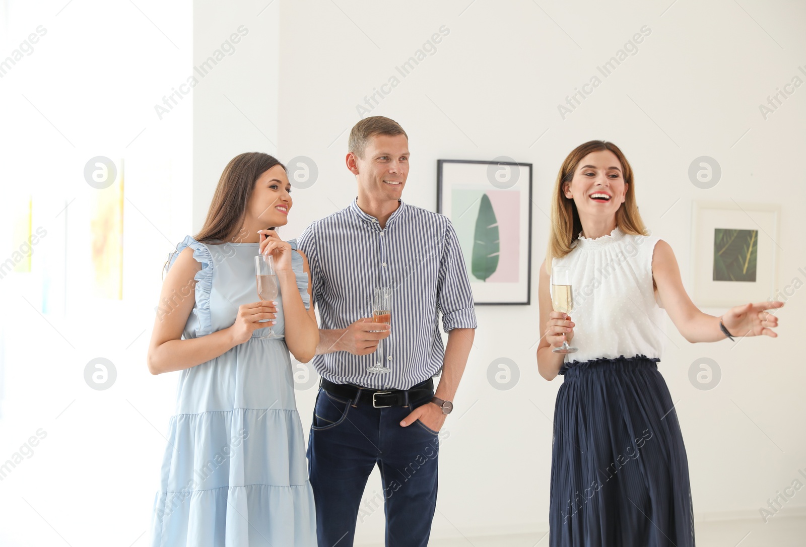 Photo of Group of people with glasses of champagne at exhibition in art gallery