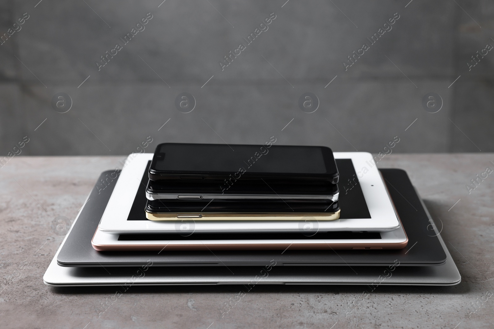 Photo of Many different modern gadgets on grey table. Space for text