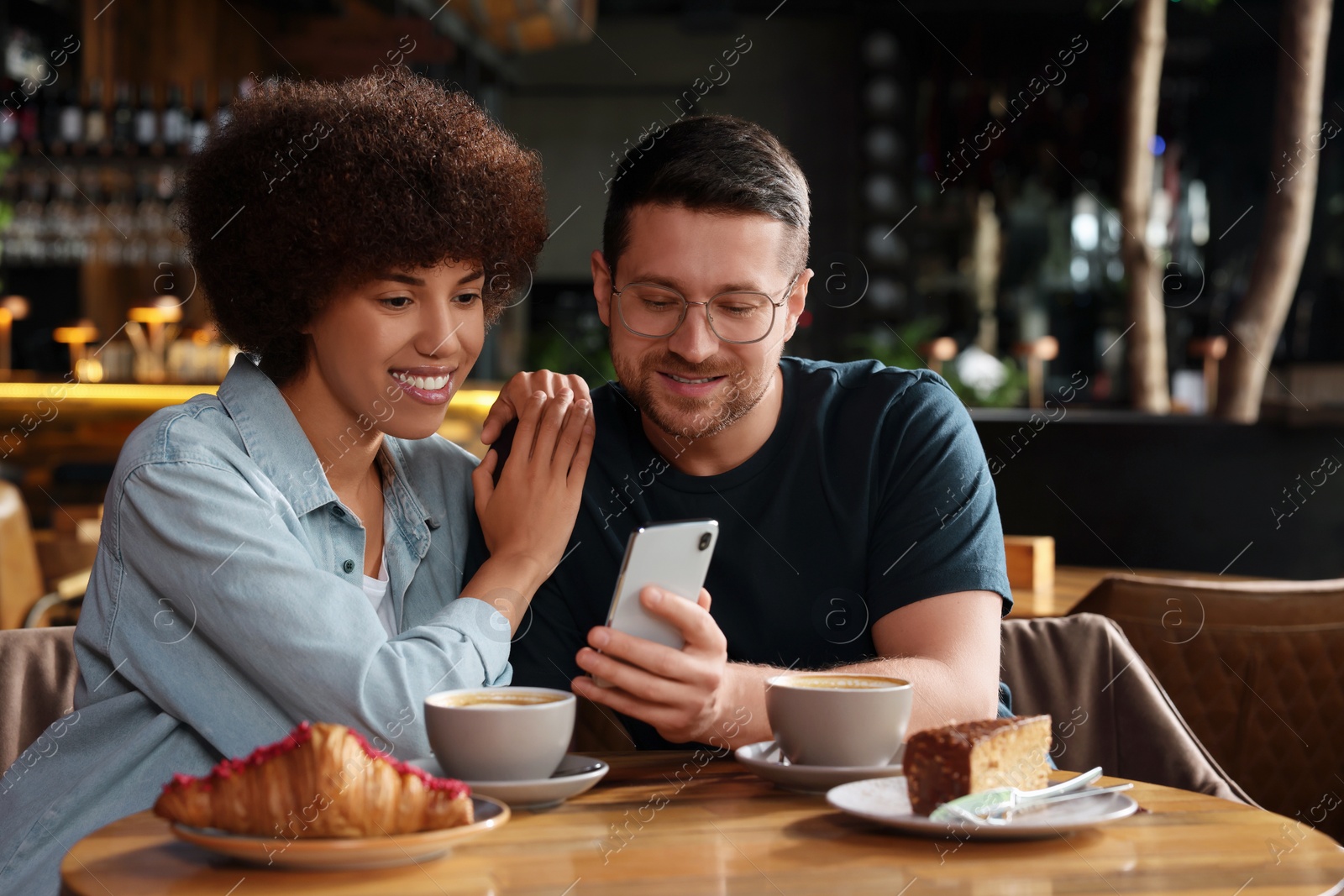 Photo of International dating. Lovely couple spending time together in cafe