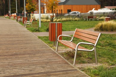 Wooden benches near pathway outdoors. Real estate