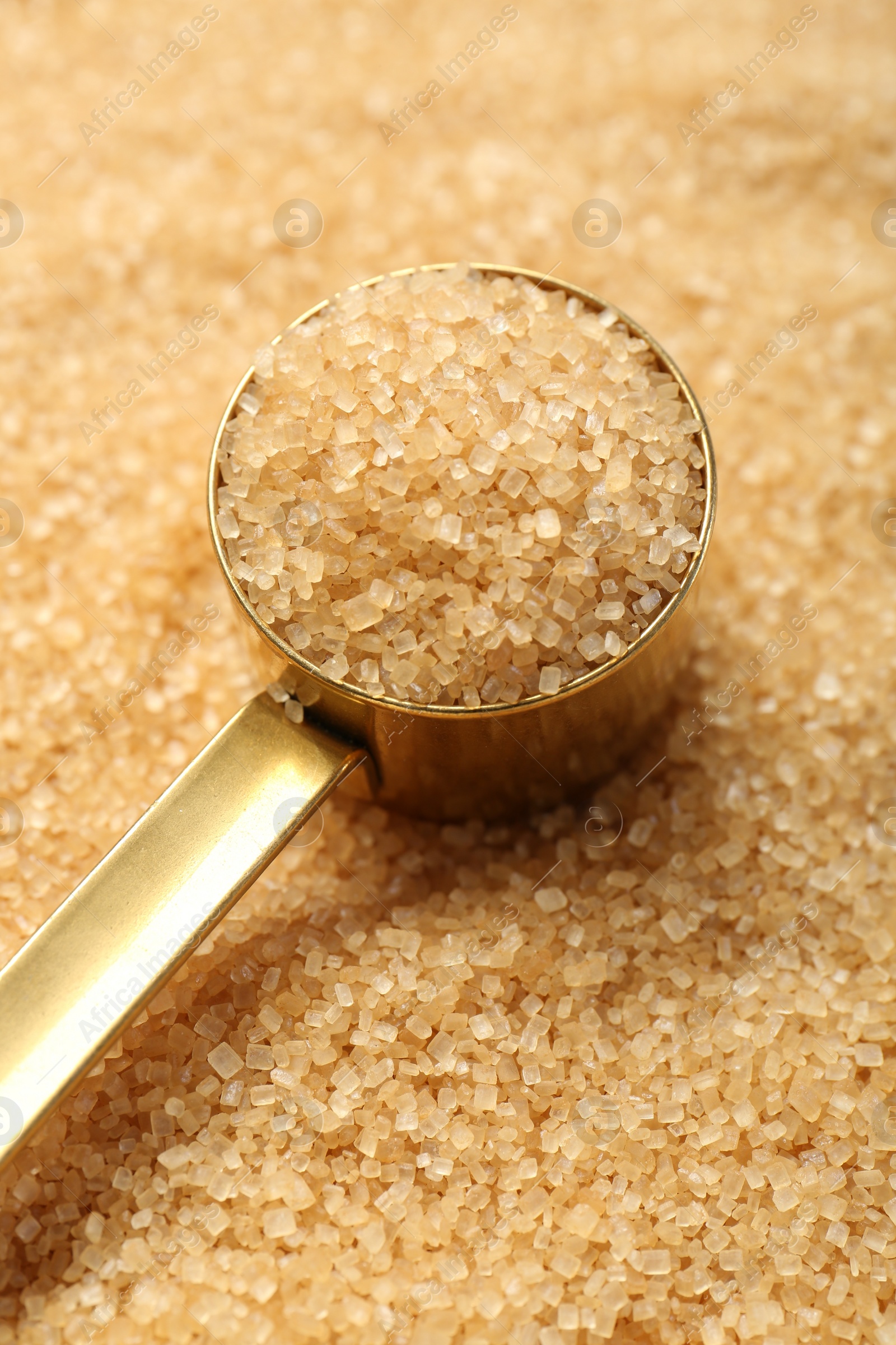 Photo of Scoop on granulated brown sugar, closeup view