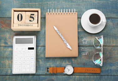 Photo of Flat lay composition with calendar and cup of coffee on light blue wooden table