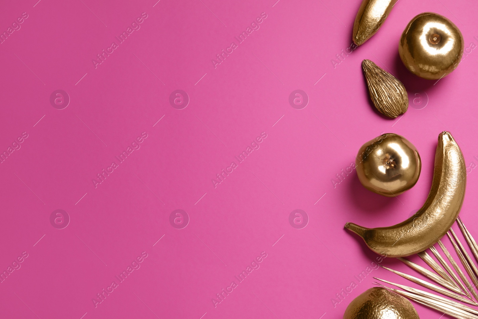Photo of Different golden fruits and palm leaf on pink background, flat lay. Space for text