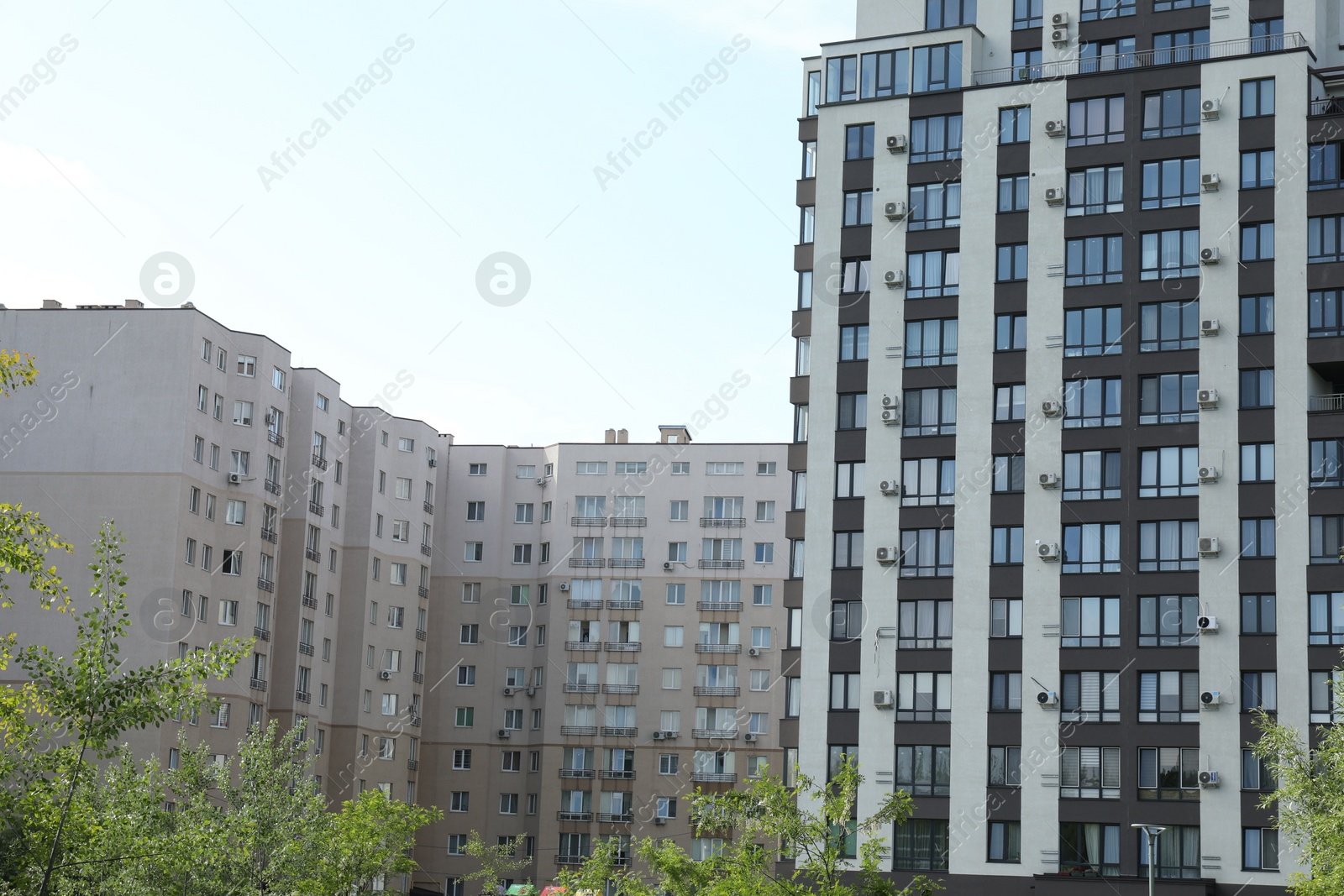 Photo of Modern buildings with big windows against blue sky outdoors