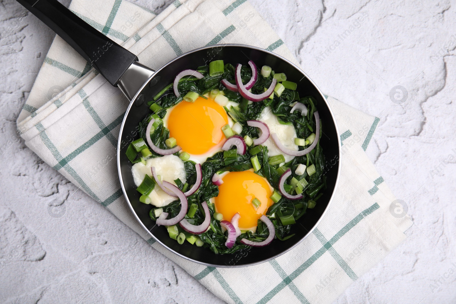 Photo of Tasty green Shakshouka served on white textured table, top view