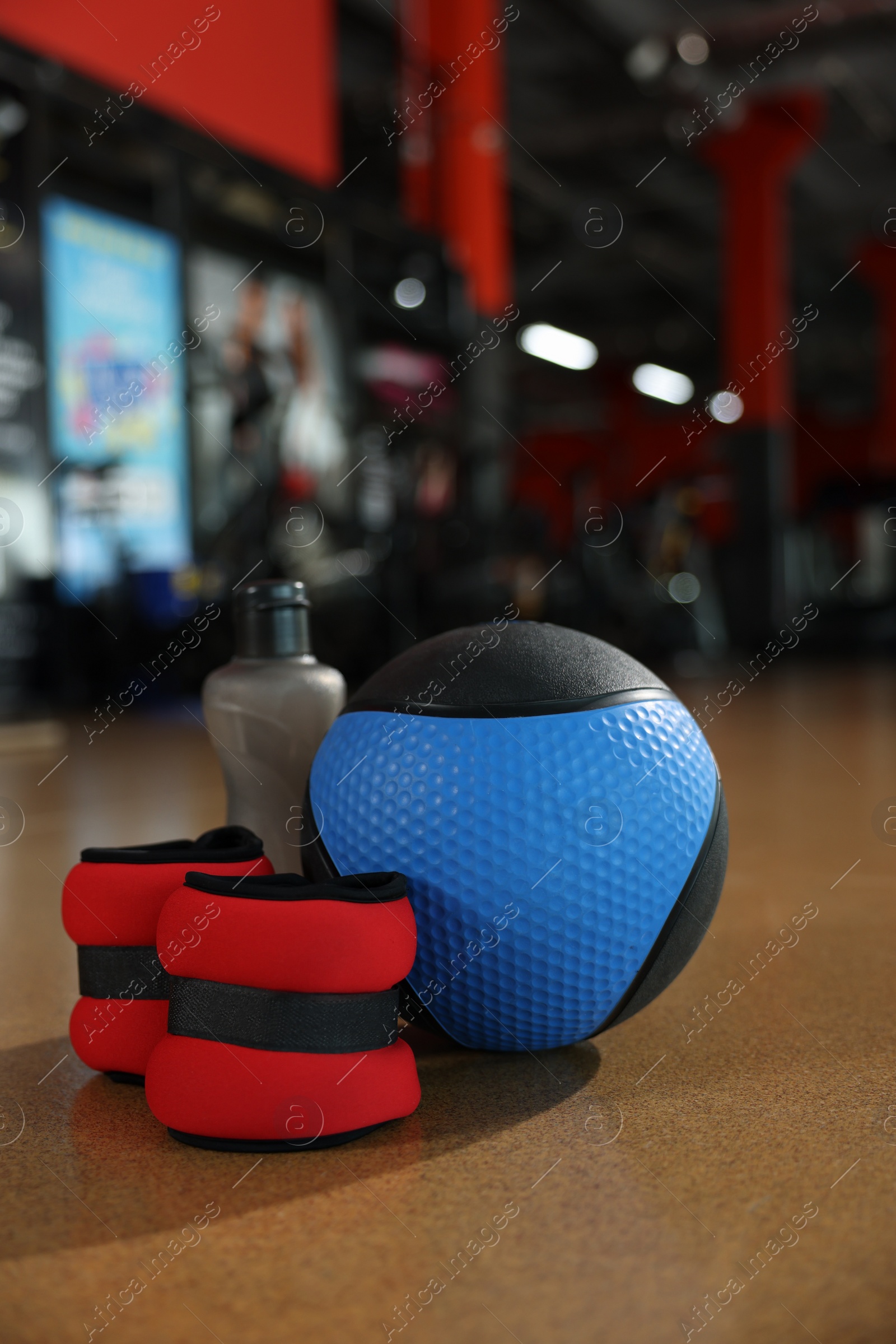 Photo of Medicine ball, bottle and weighting agents on floor in gym