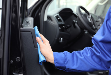 Photo of Car wash worker cleaning automobile interior, closeup