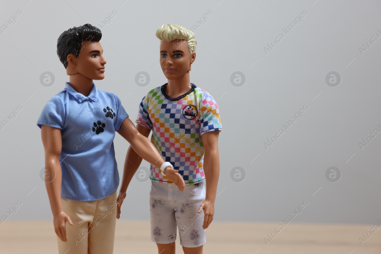 Photo of Leiden, Netherlands - September 20, 2023: Stylish Ken dolls on light gray background, space for text