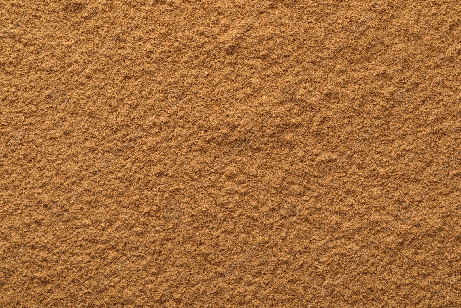 Photo of Dry aromatic cinnamon powder as background, top view