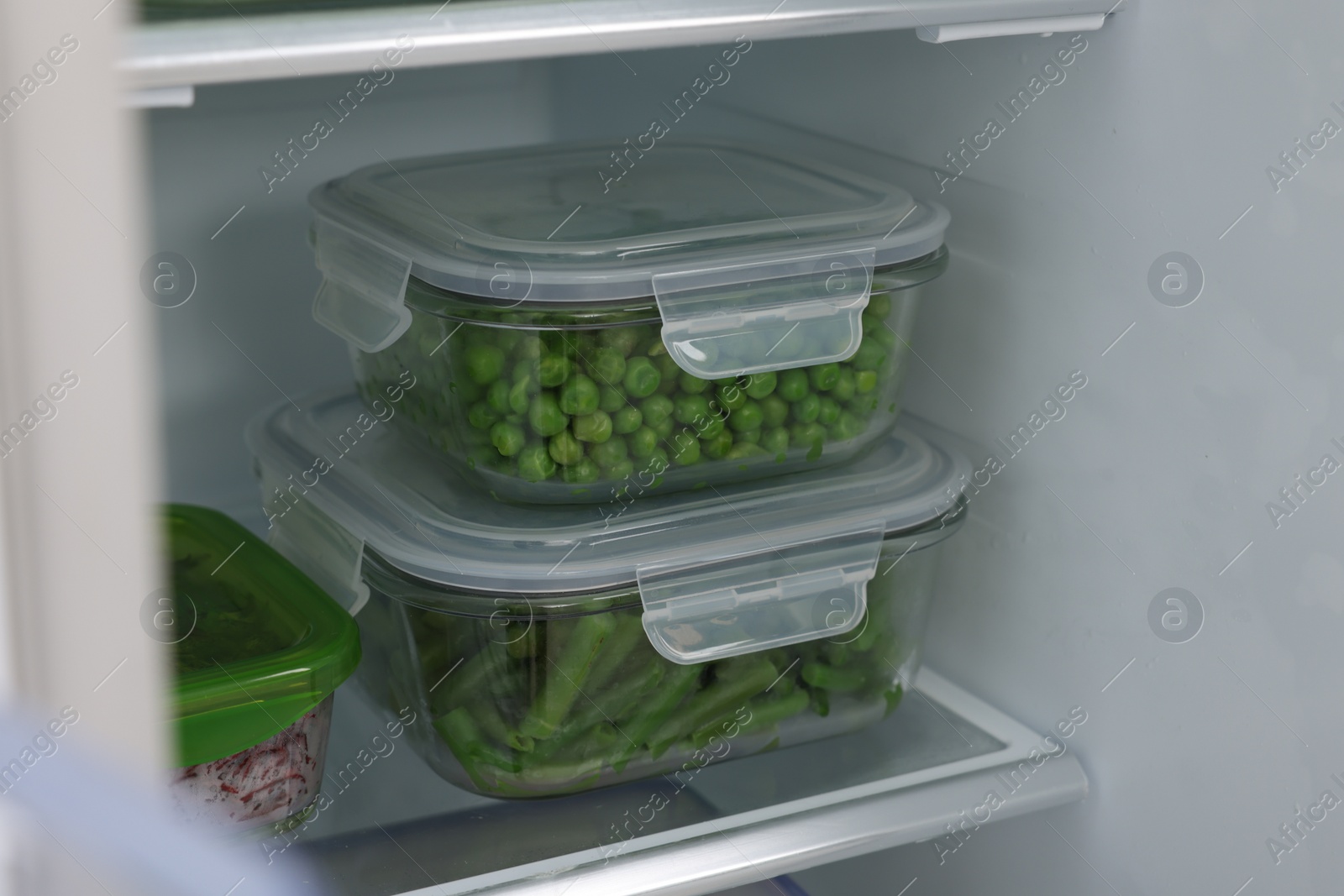 Photo of Glass containers with different fresh products in fridge. Food storage