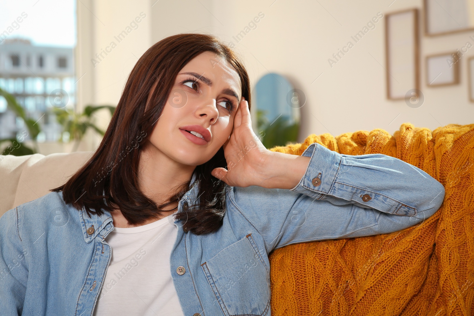 Photo of Young woman suffering from headache indoors. Hormonal disorders