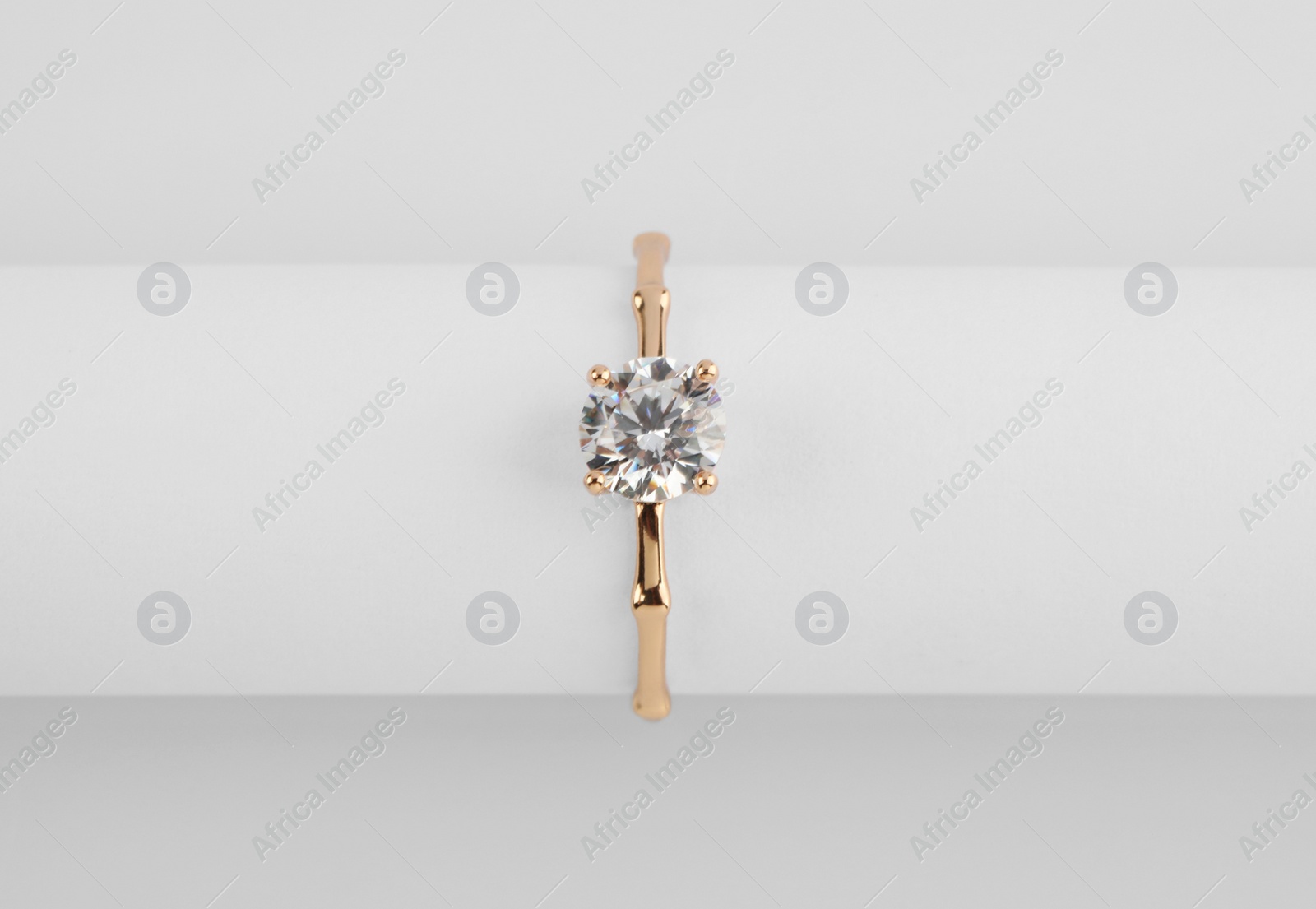 Photo of Beautiful engagement ring with gemstone on white background, top view