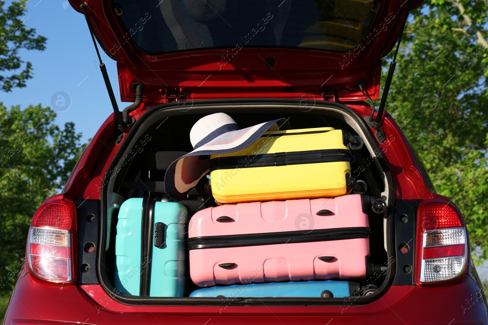 Photo of Family car with open trunk full of luggage outdoors, closeup