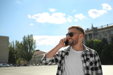 Young man talking on smartphone on city street