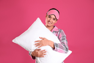 Photo of Beautiful woman with pillow on pink background. Bedtime
